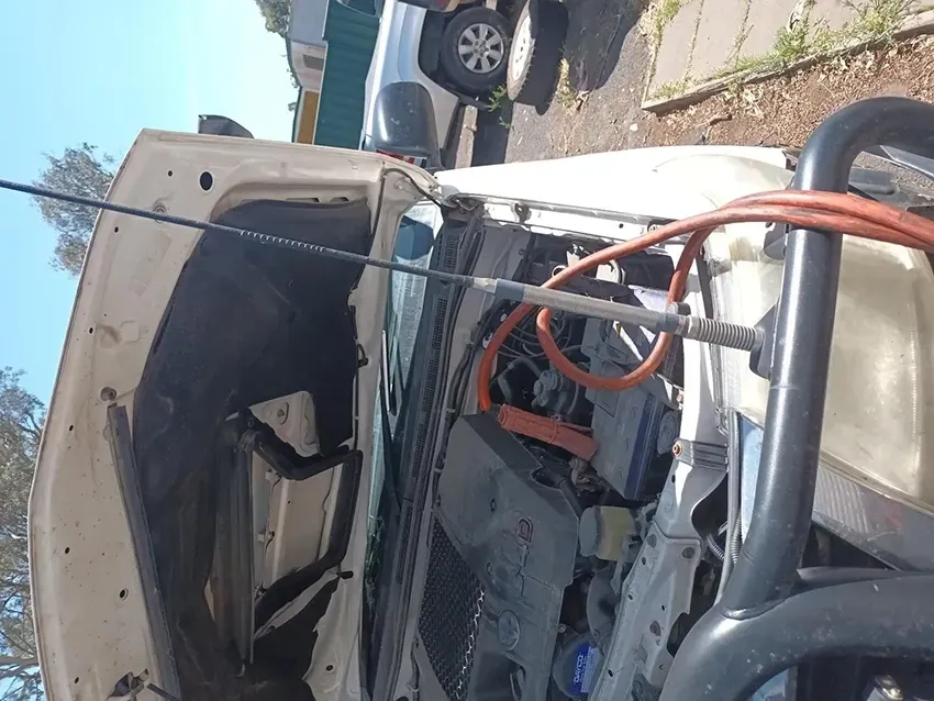 A White Car With the Hood Up and a Hose Attached to It — South West 4WD Wreckers In Brisbane, QLD