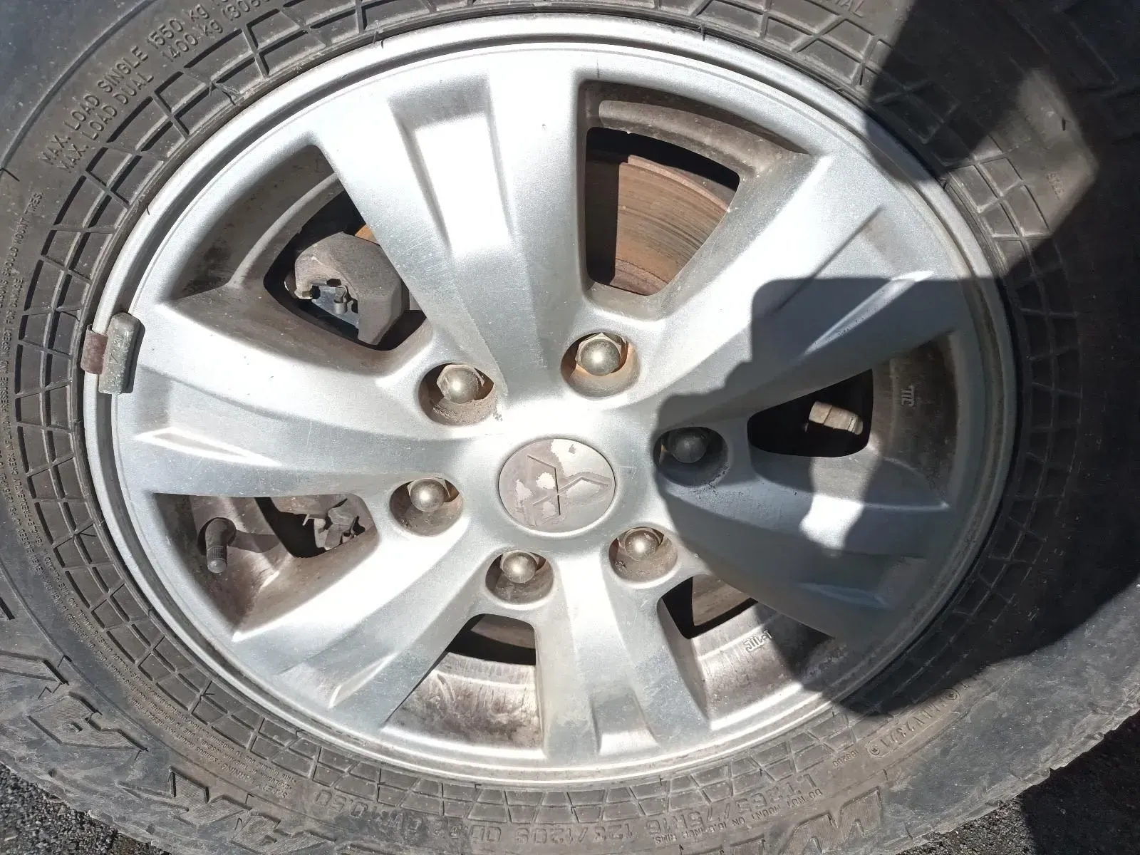 Silver Car Wheel With Tyre, Showing Lug Nuts and a Peugeot Logo — South West 4WD Wreckers In Brisbane, QLD