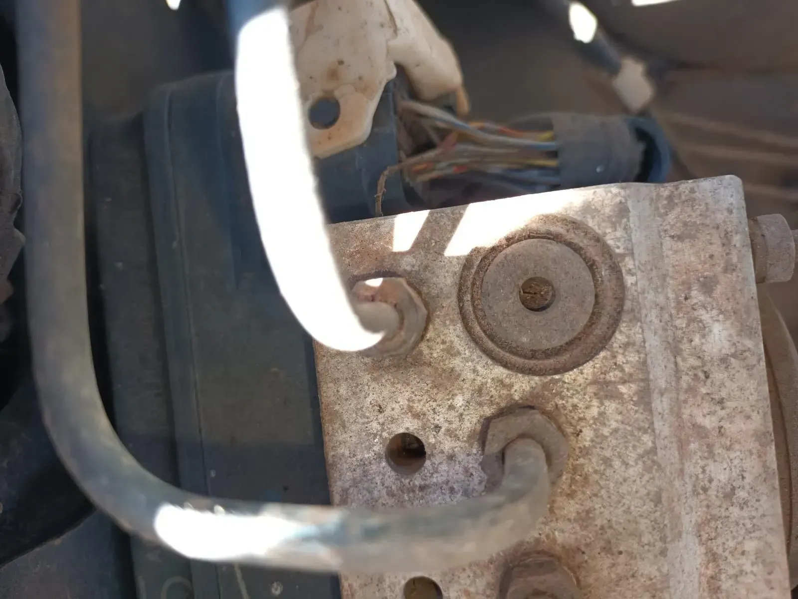 Rusty Car Part With Tubes and a Bolt, Likely the Abs Module, in an Engine Bay — South West 4WD Wreckers In Brisbane, QLD