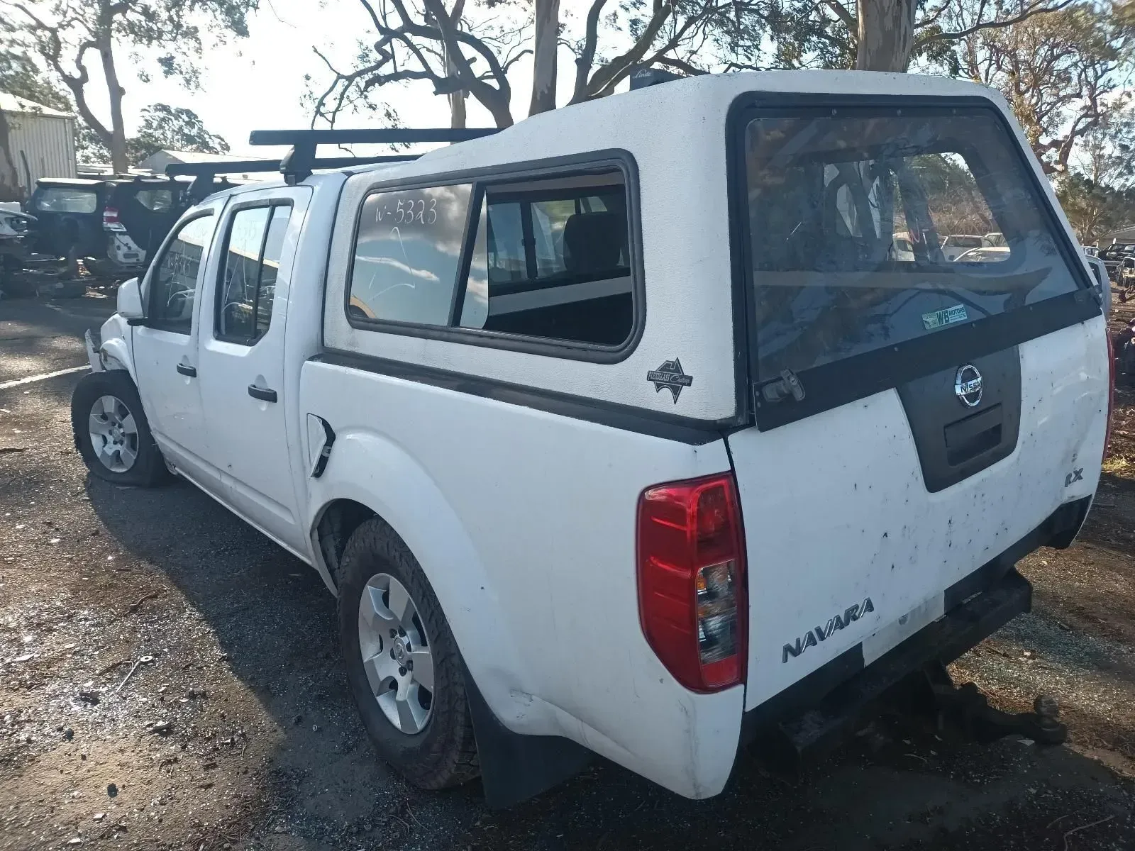 White Nissan Navara Pickup Truck With a Canopy, Parked Outdoors — South West 4WD Wreckers In Brisbane, QLD