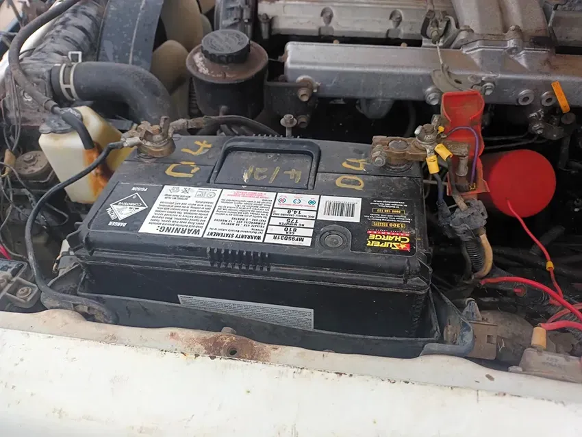 A Black Battery is Sitting Under the Hood of a Car — South West 4WD Wreckers In Brisbane, QLD 