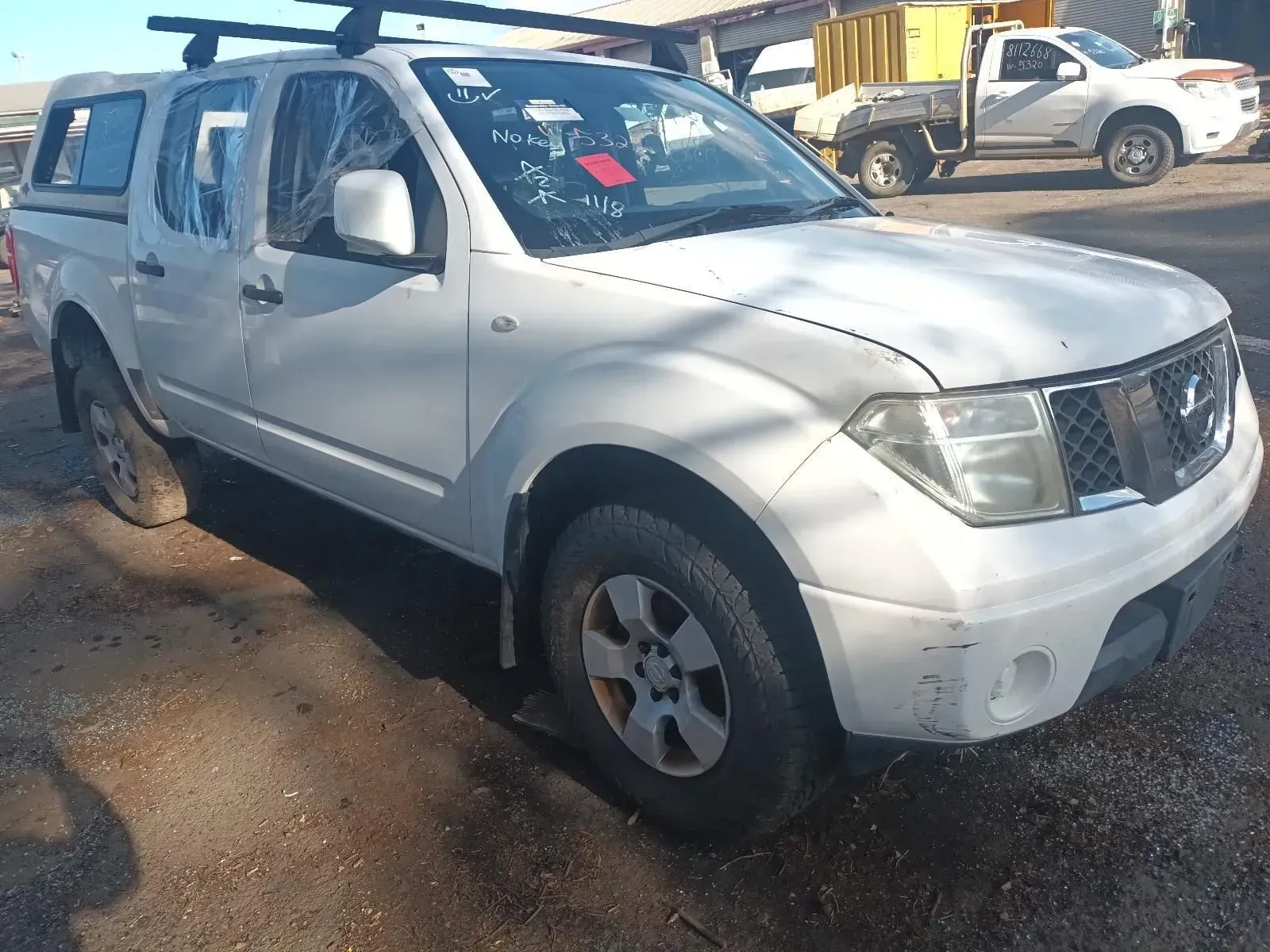 White Nissan Navara Pickup Truck Parked in a Dusty Lot — South West 4WD Wreckers In Brisbane, QLD