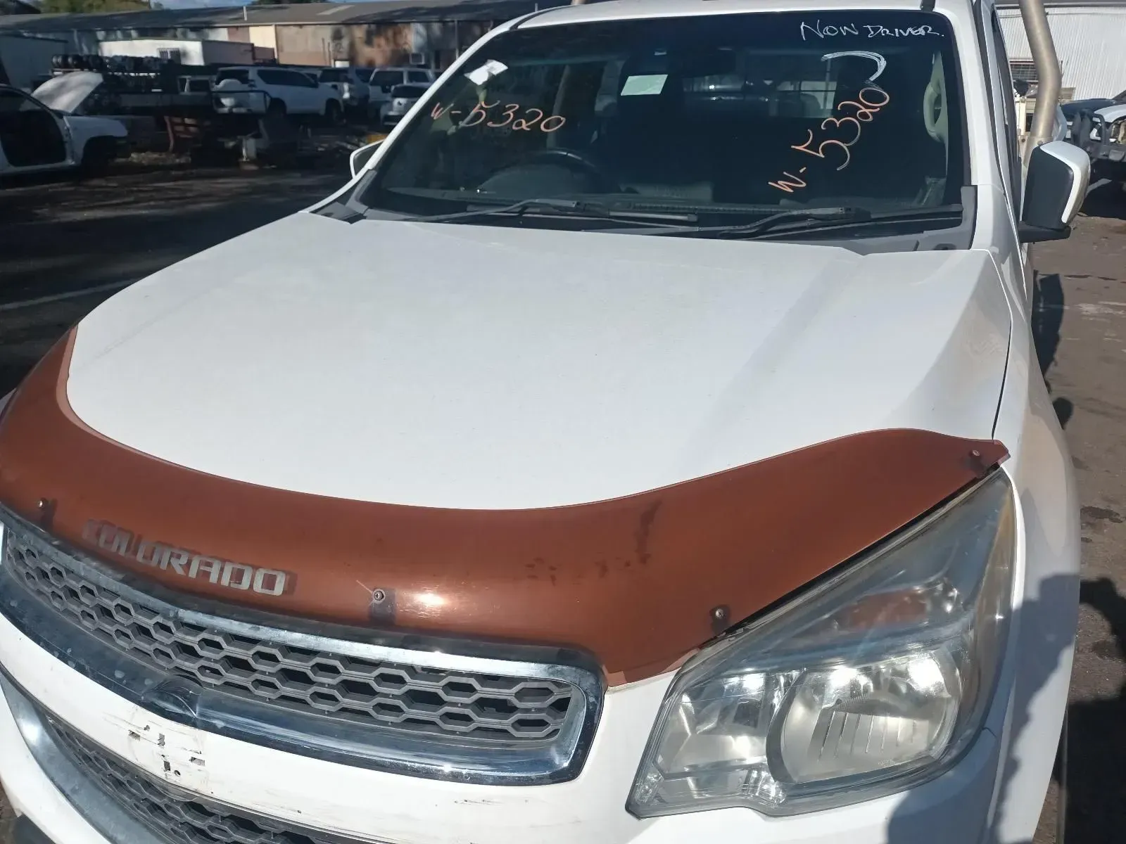 White Chevrolet Colorado Pickup Truck With Brown Hood Protector in a Junkyard — South West 4WD Wreckers In Brisbane, QLD