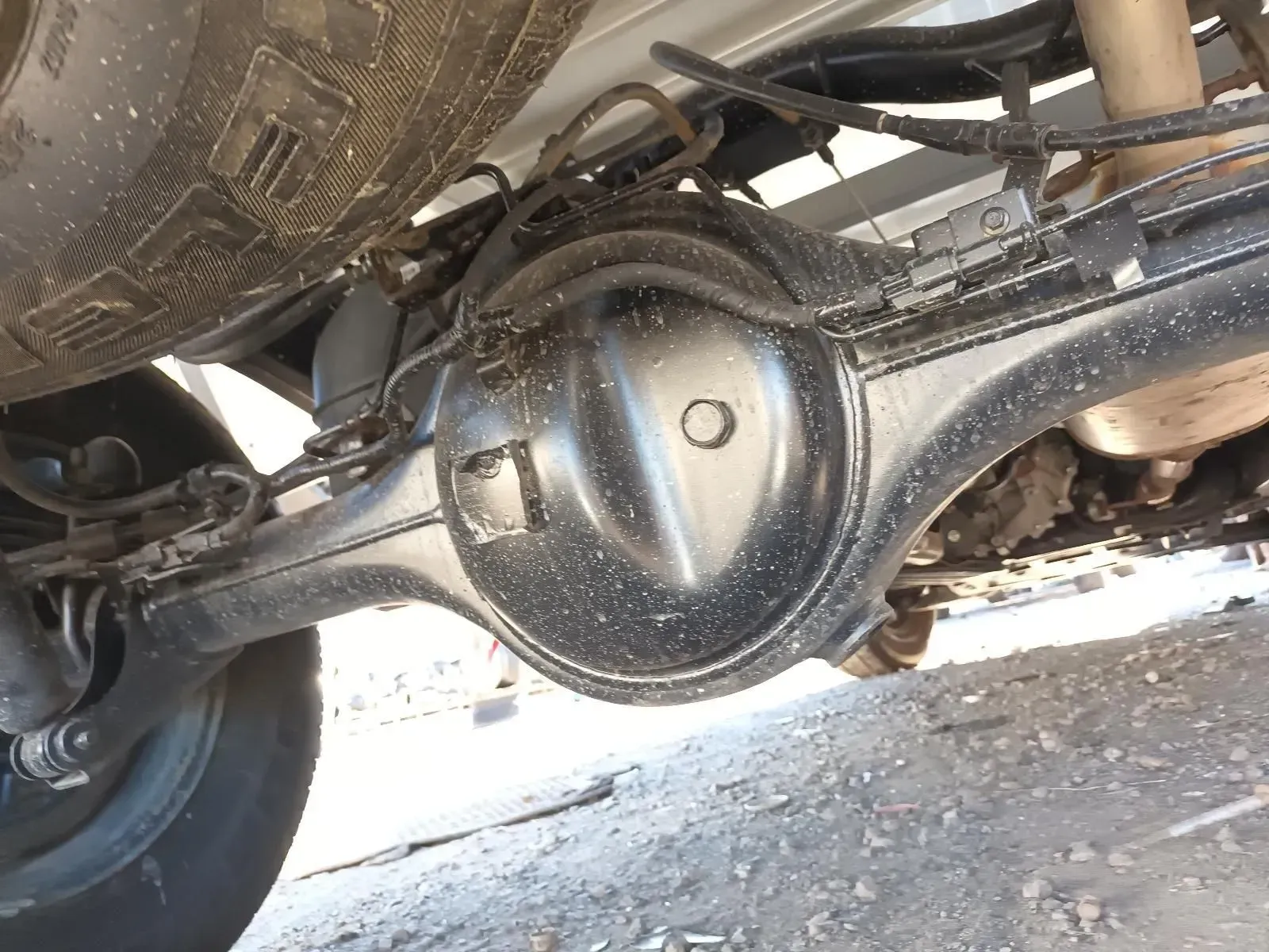 Black Car's Rear Axle With Spare Tyre Above It — South West 4WD Wreckers In Brisbane, QLD