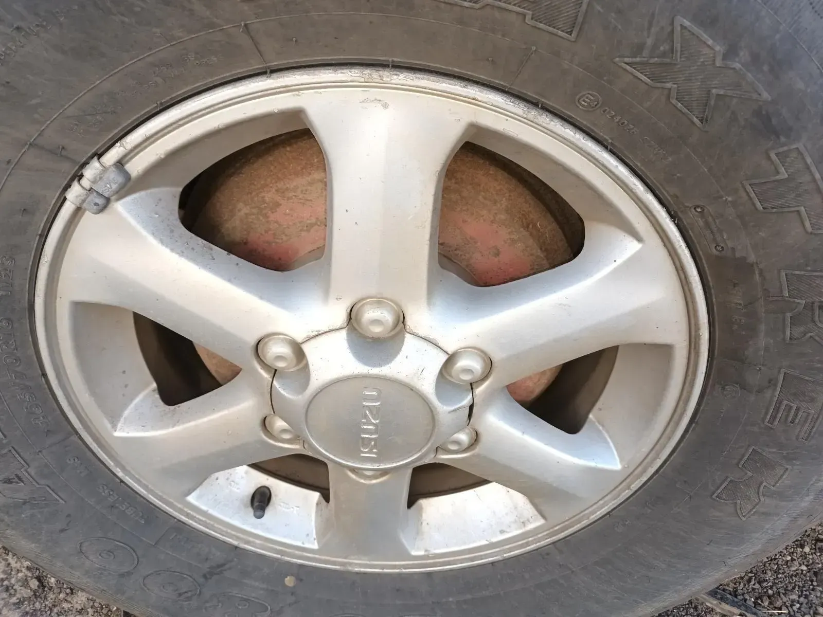 A Silver Isuzu Car Wheel With a Worn Tyre; the Brake Rotor is Visible — South West 4WD Wreckers In Brisbane, QLD