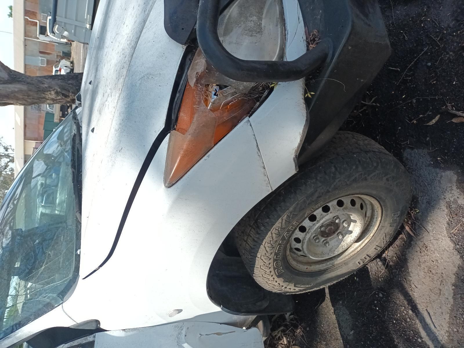 A White Car with a Broken Headlight is Parked on the Side of the Road — South West 4WD Wreckers in Harristown, QLD