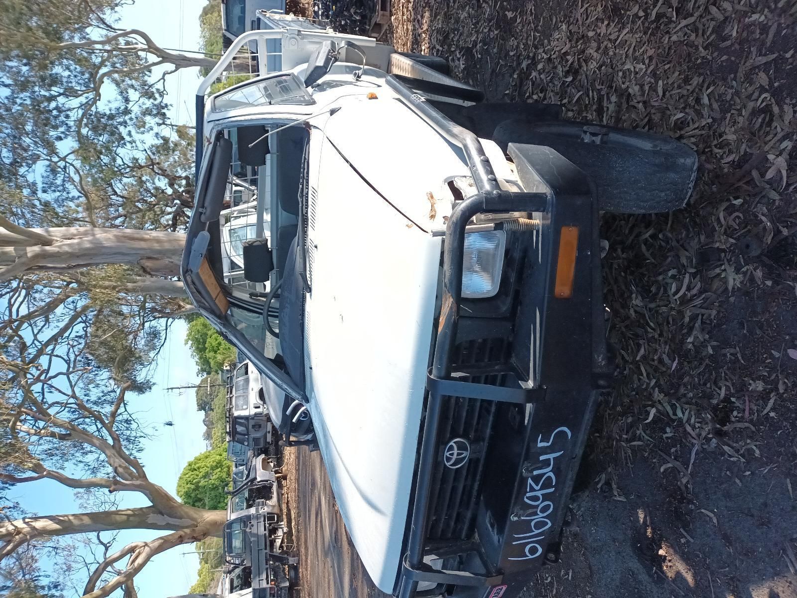 A White Truck is Sitting in a Pile of Junk — South West 4WD Wreckers in Harristown, QLD