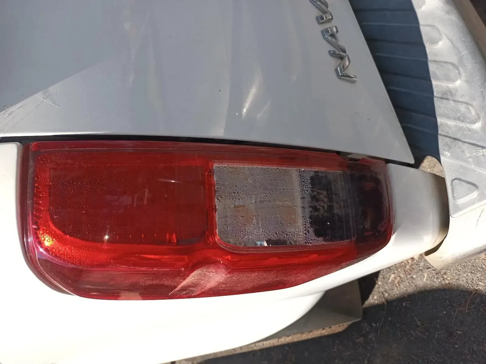 White Car's Taillight, Right Side Damaged and Faded, Showing Red and Gray Sections — South West 4WD Wreckers In Brisbane, QLD