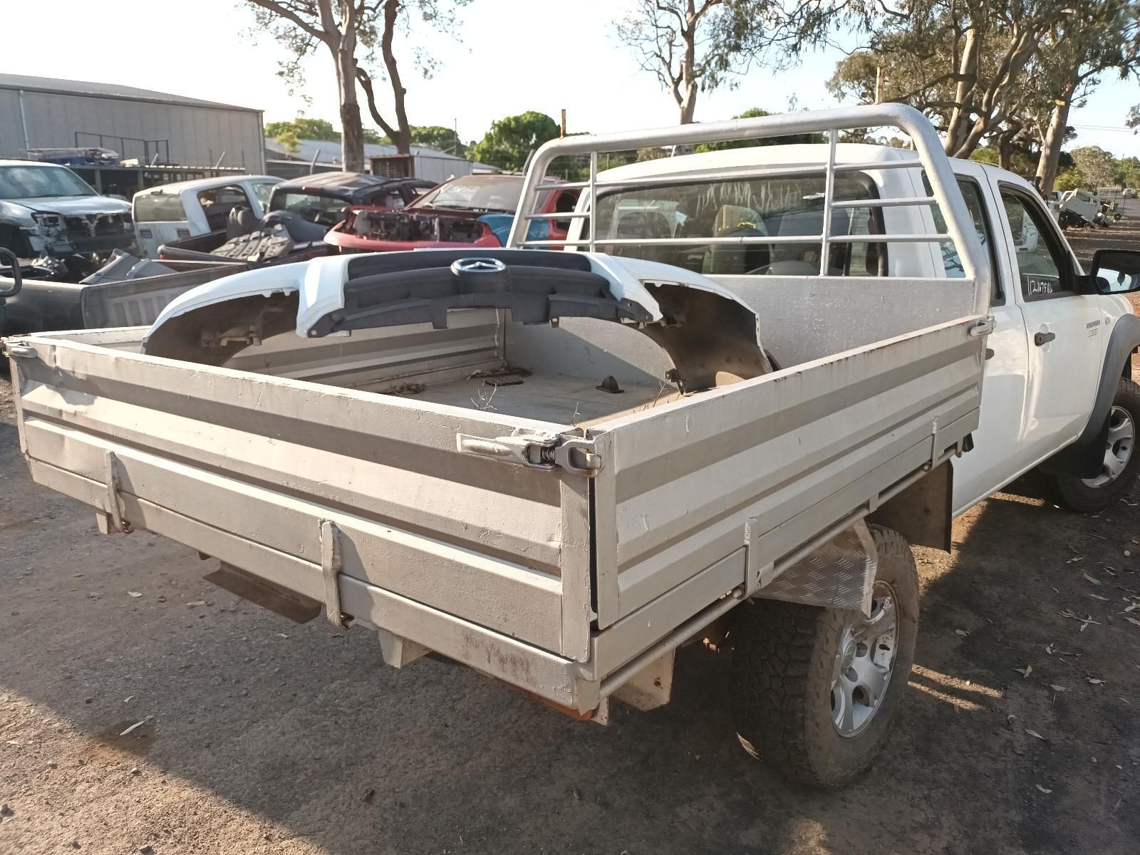 A White Truck with a Dirty Bed is Parked in a Lot — South West 4WD Wreckers in Harristown, QLD