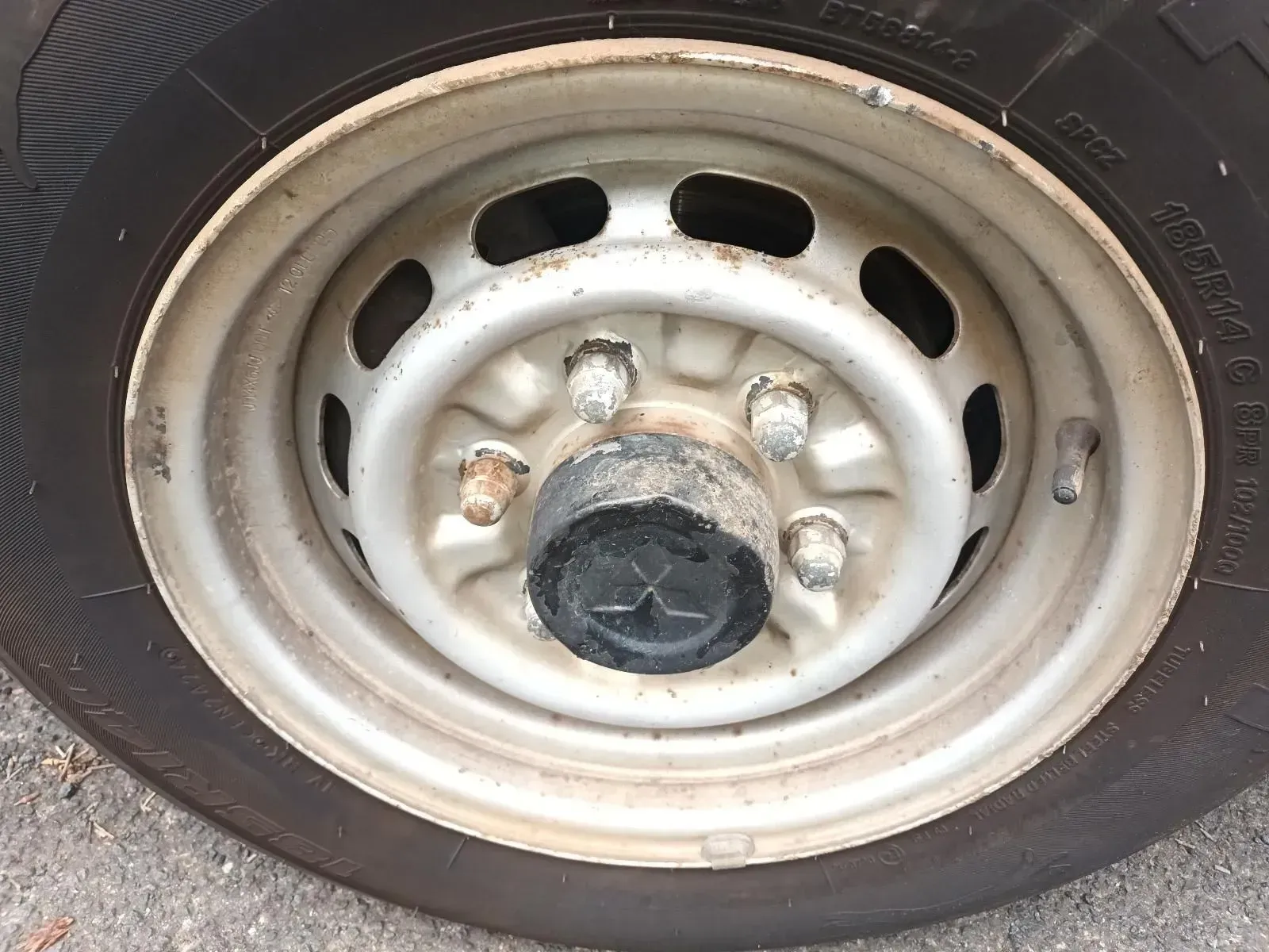 Close-up of a Dirty, Light-colored Steel Wheel With a Black Tyre and Center Cap — South West 4WD Wreckers In Brisbane, QLD