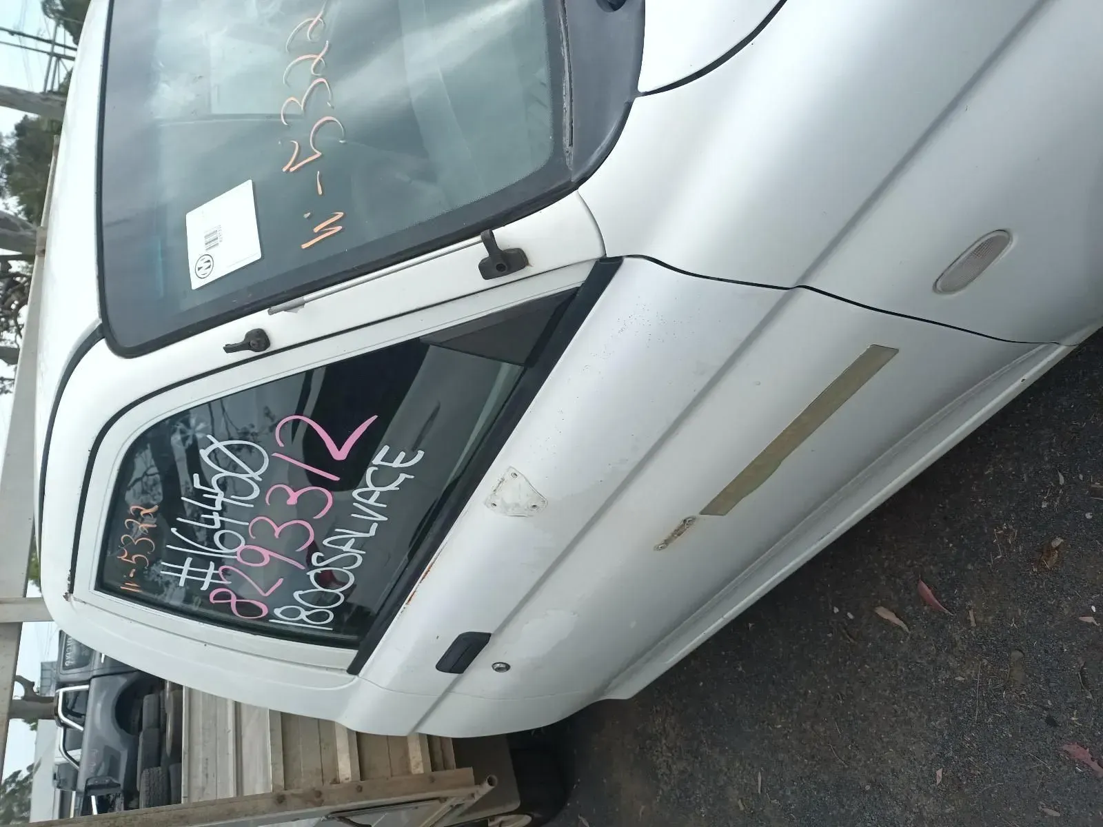 White Car Door in a Salvage Yard; Text Written on Window — South West 4WD Wreckers In Brisbane, QLD