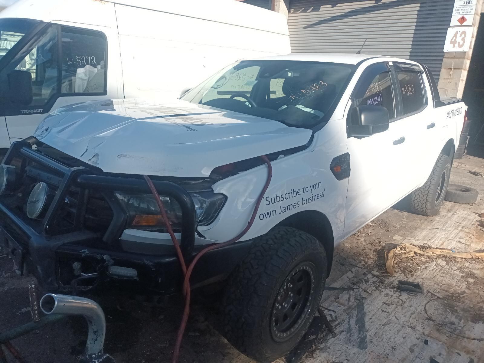 A White Truck is Sitting on the Side of the Road Next to a White Van — South West 4WD Wreckers in Harristown, QLD 