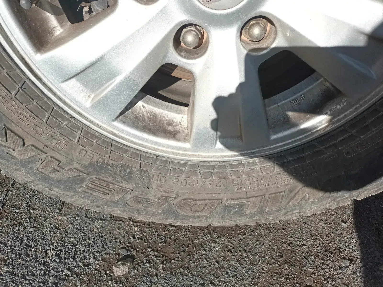 Close-up of a Car Tyre and Silver Wheel, Showing Treads and Lug Nuts on Asphalt — South West 4WD Wreckers In Brisbane, QLD
