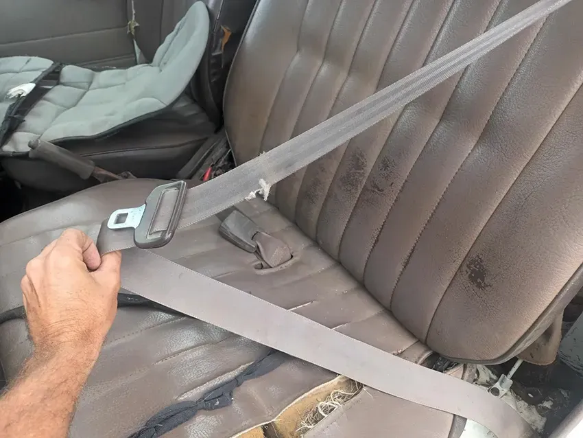A Person is Putting on a Seat Belt in a Car — South West 4WD Wreckers In Brisbane, QLD