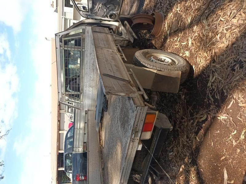 A Truck With a Flat Bed is Parked in the Dirt — South West 4WD Wreckers In Harristown, QLD