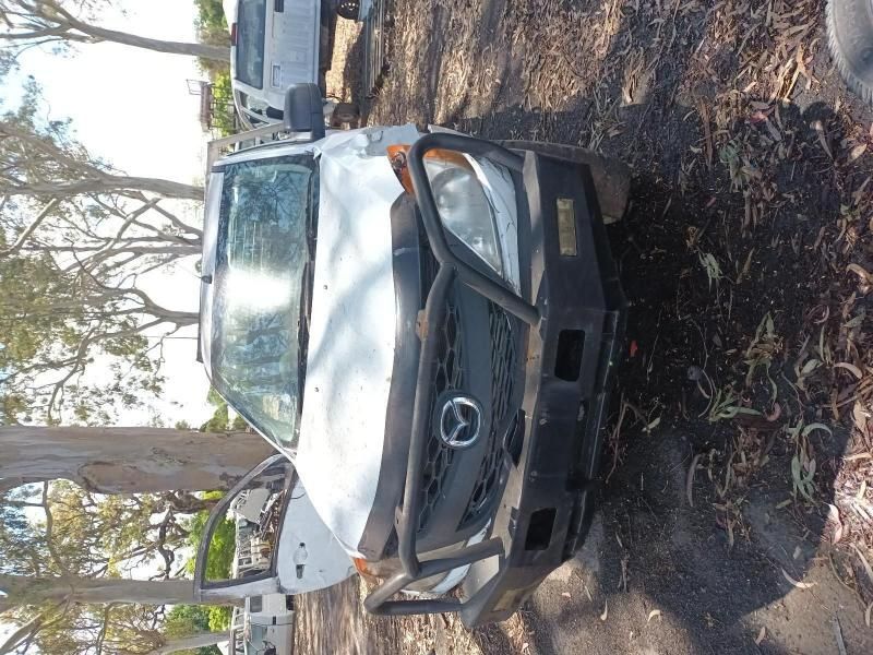 A White Truck With a Black Bumper is Parked in the Dirt — South West 4WD Wreckers In Harristown, QLD