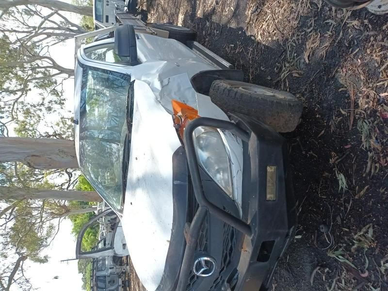 A White Car With a Black Bumper is Parked in the Dirt — South West 4WD Wreckers In Harristown, QLD