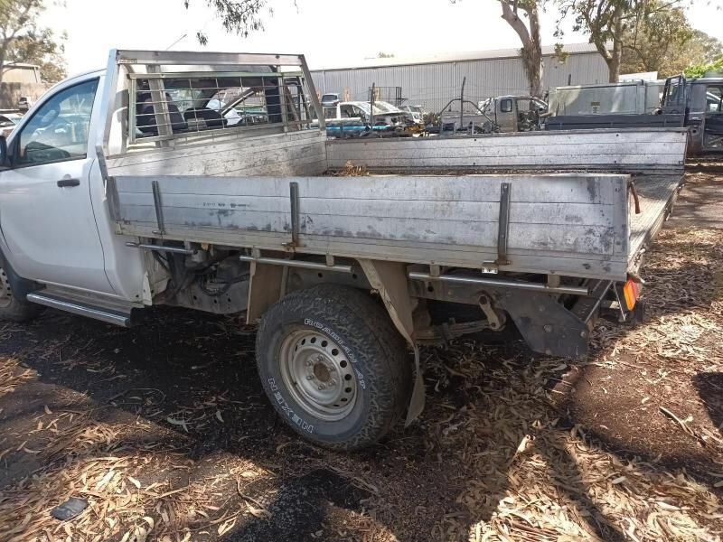 A White Truck With a Flat Bed is Parked in the Dirt — South West 4WD Wreckers In Harristown, QLD