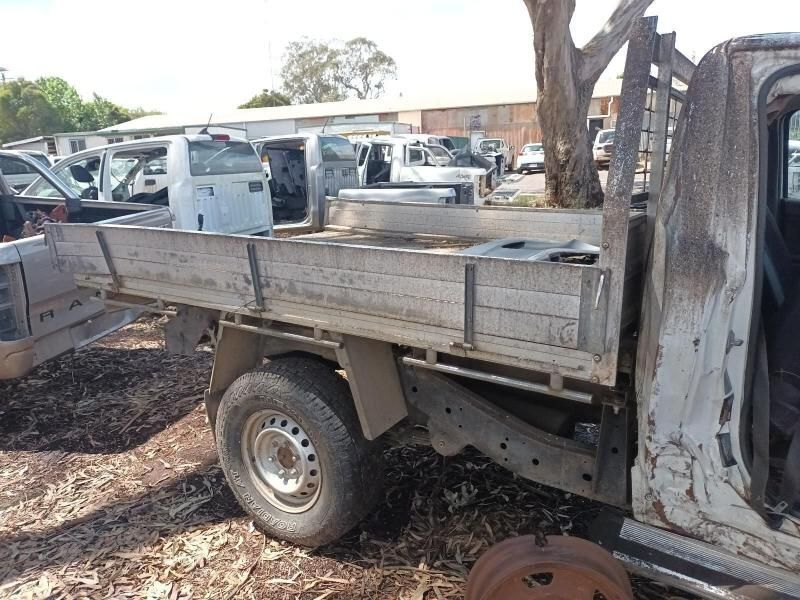 A White Truck With a Wooden Bed is Parked in a Lot — South West 4WD Wreckers In Harristown, QLD