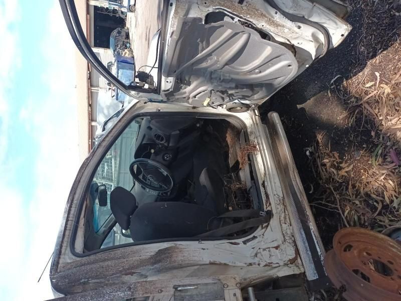 A White Truck With the Door Open is Sitting in the Grass — South West 4WD Wreckers In Harristown, QLD