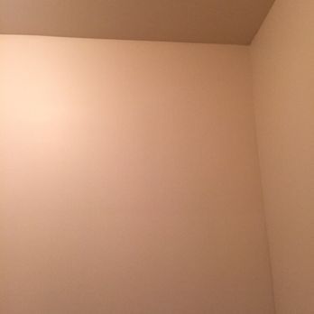 Cream-colored walls and ceiling in a corner of a room, creating an empty space.