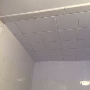White tiled shower ceiling and walls.