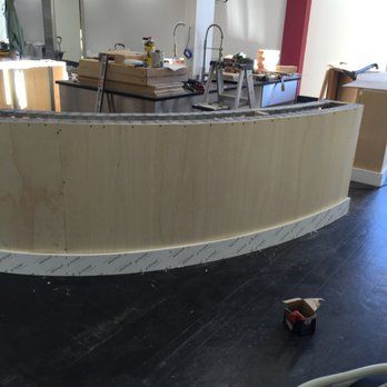 Wooden curved bar under construction in a room.