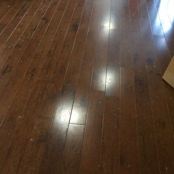 Dark brown hardwood floor with glossy finish, reflecting light.
