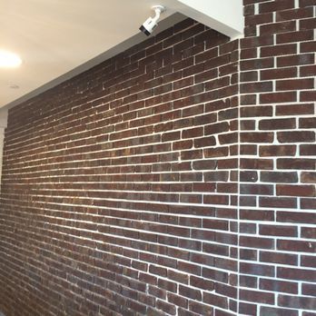Brick wall with white mortar, security camera mounted on the ceiling.