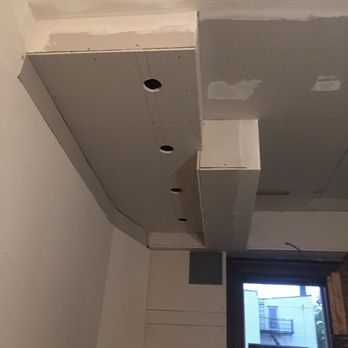 Construction of a drywall ceiling with recessed lighting.