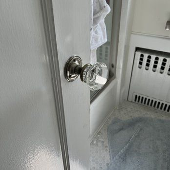 Crystal doorknob on a white door in a bathroom.