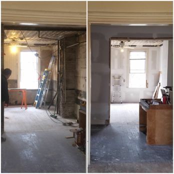 Room undergoing renovation: bare brick, construction materials, then finished with gray walls, light fixtures.