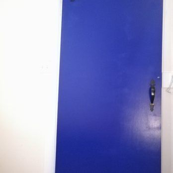 Blue door with black handle against a white wall.