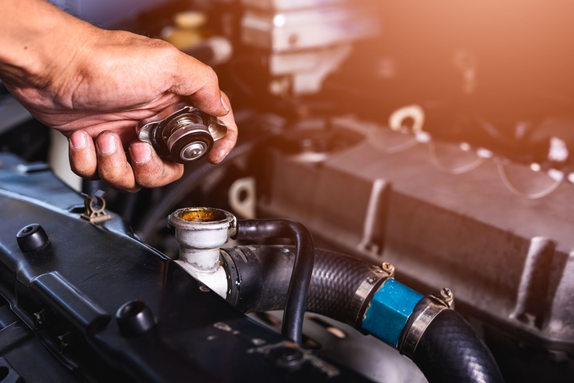 A Hand Holds a Removed Metal Radiator Cap — O'Toole Automotive In Tuggerah, NSW
