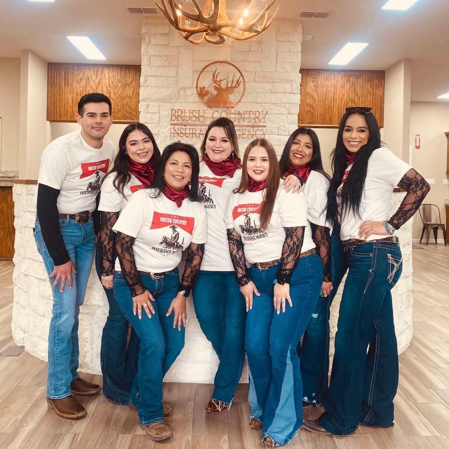 A group of people are posing for a picture in front of a brick wall.
