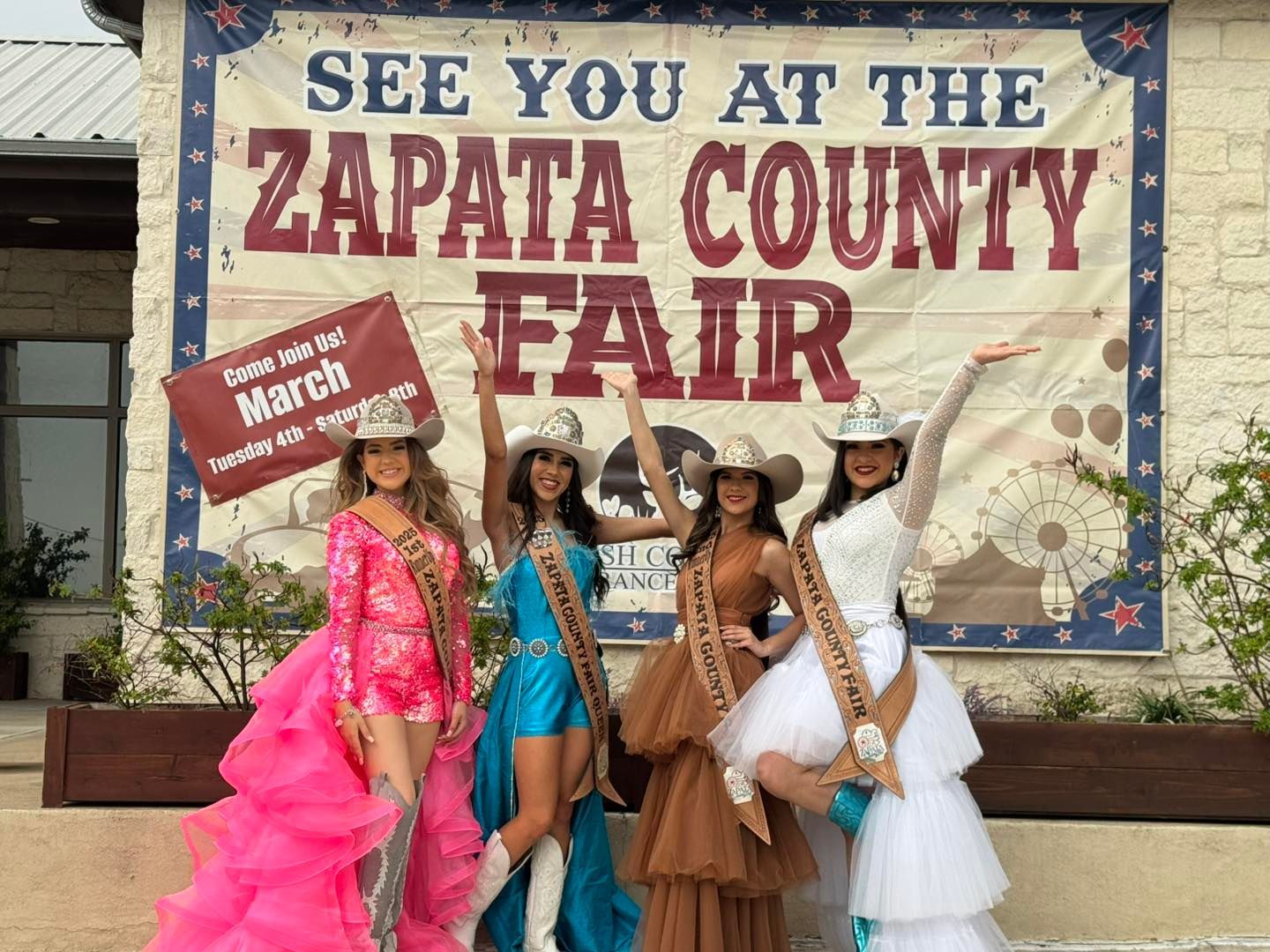 A group of women standing in front of a sign.