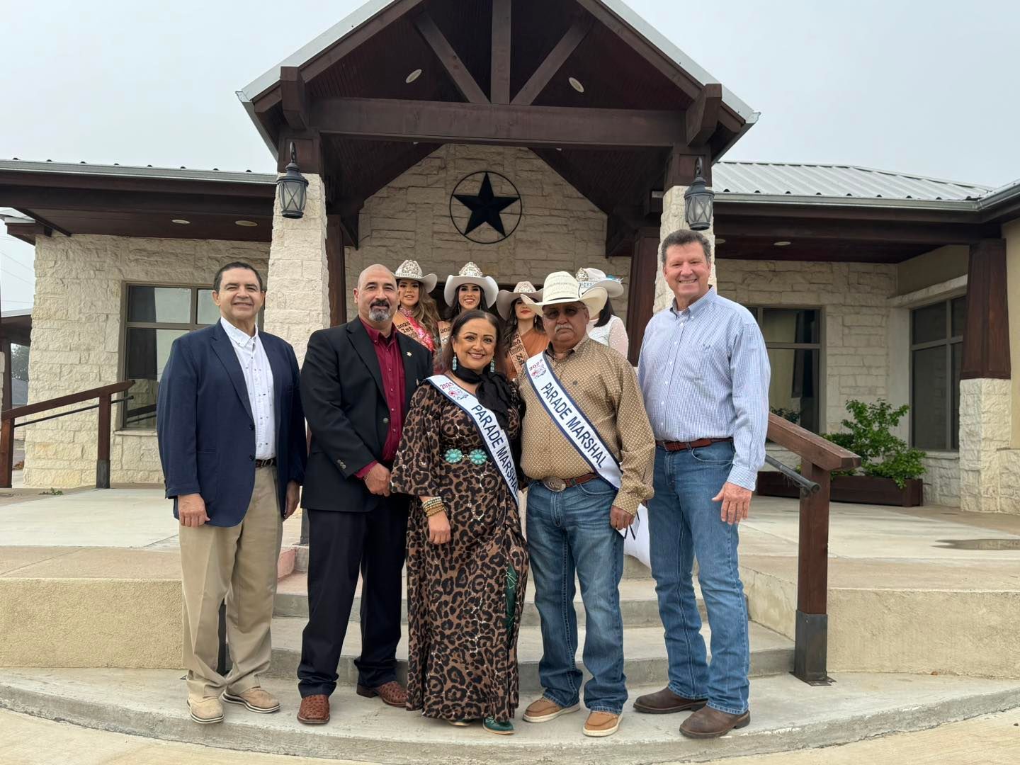 A group of people are posing for a picture in front of a building.