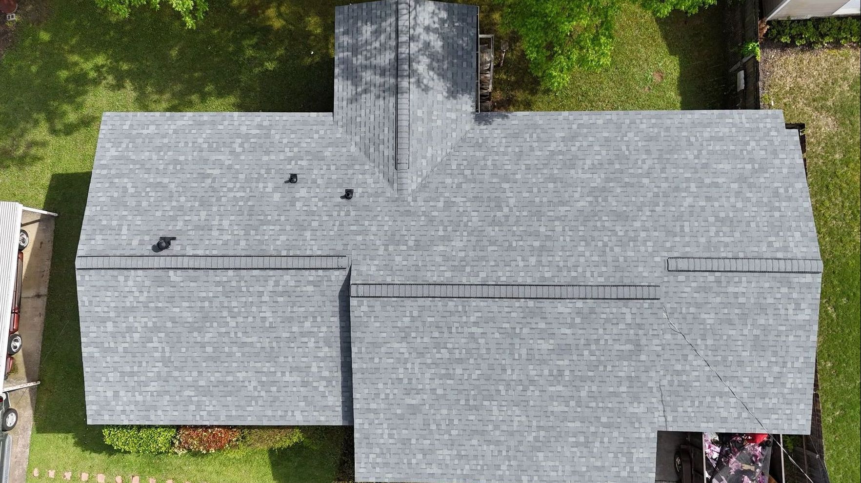 An aerial view of a house with a gray roof