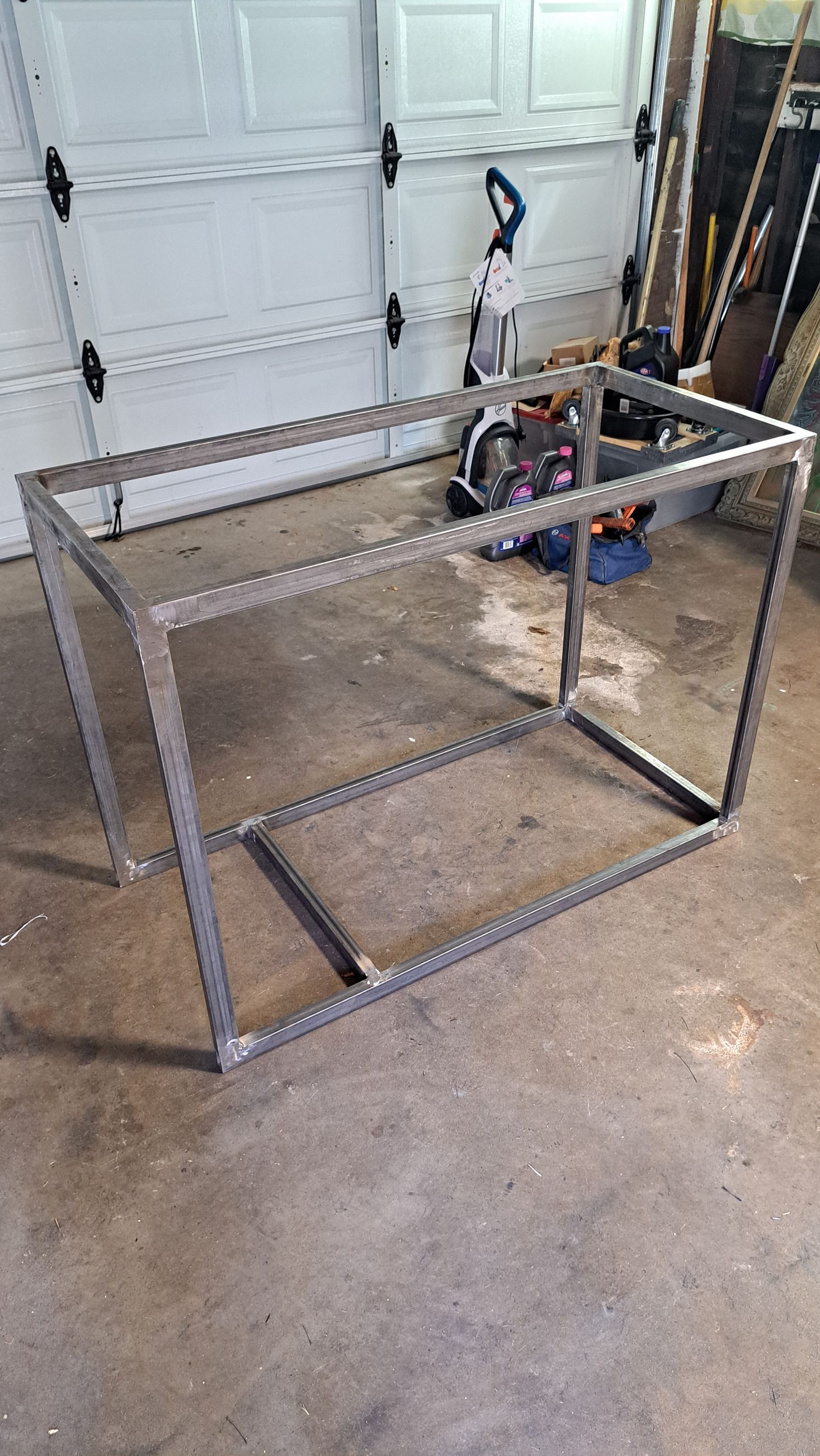 Welded metal frame for a table in a garage.
