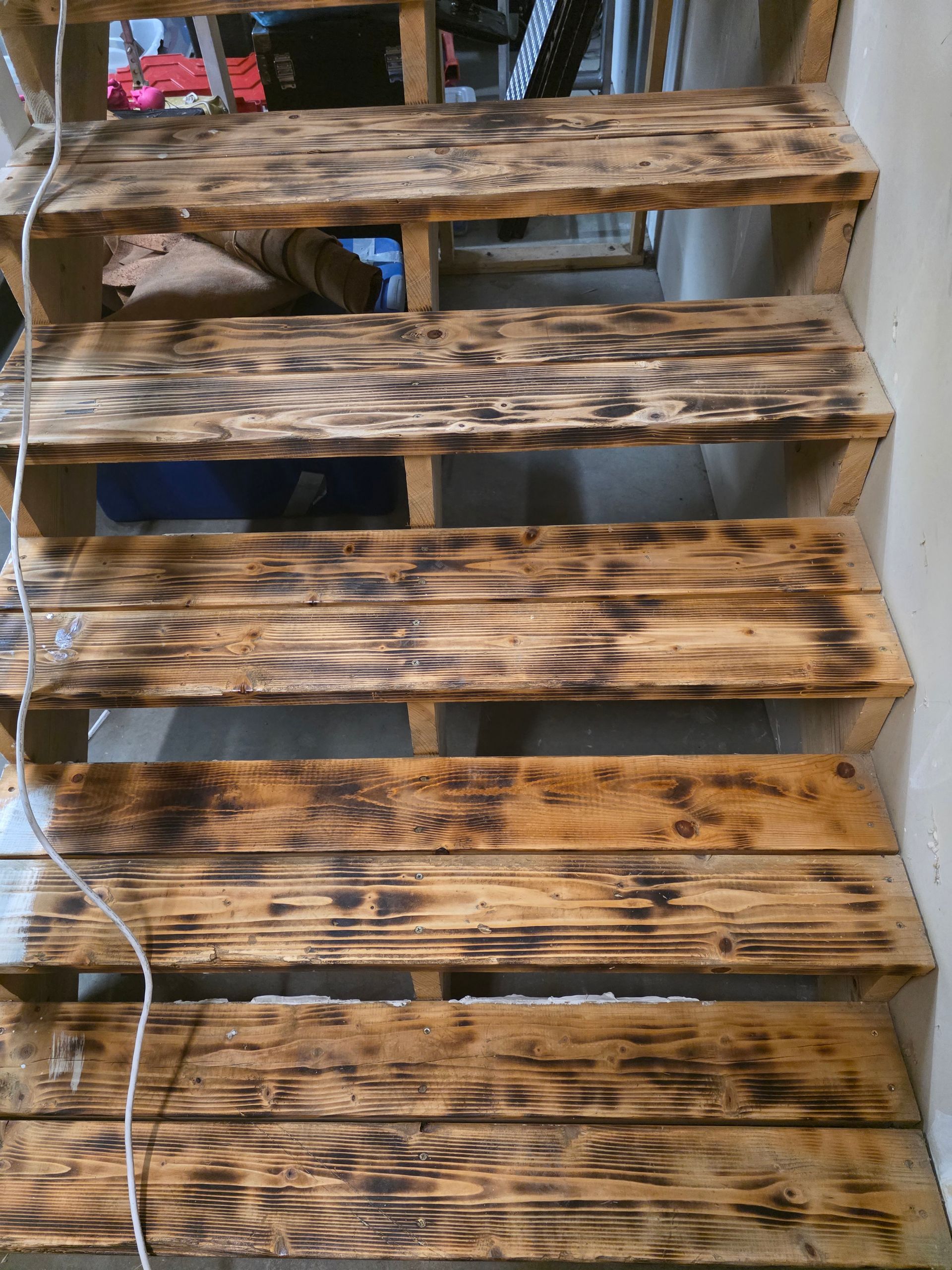 Wooden stairs with dark charred markings.