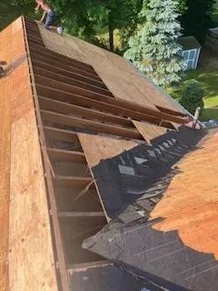 A man is working on the roof of a house.