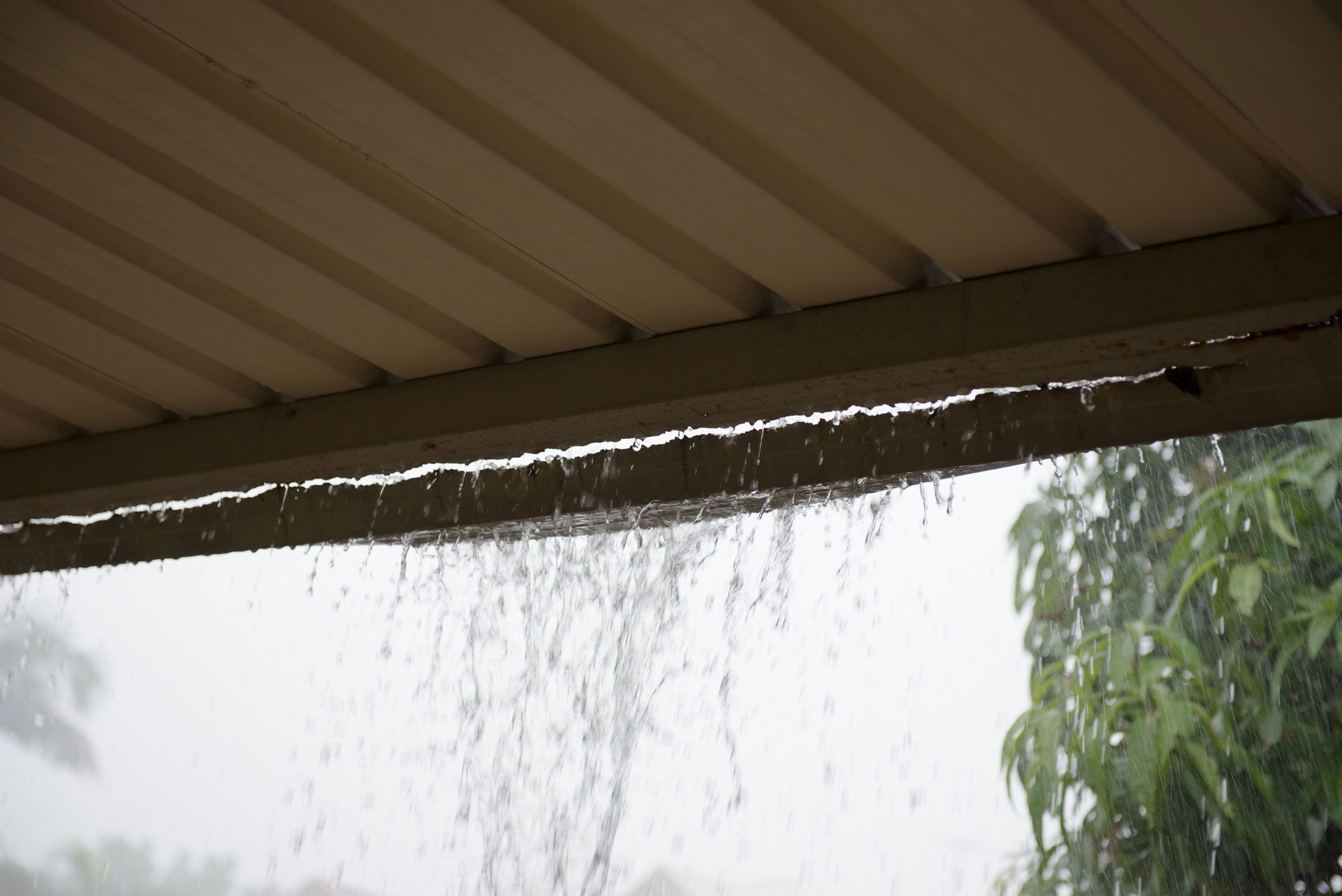 Storm-damaged roof and gutter in need of professional repair.