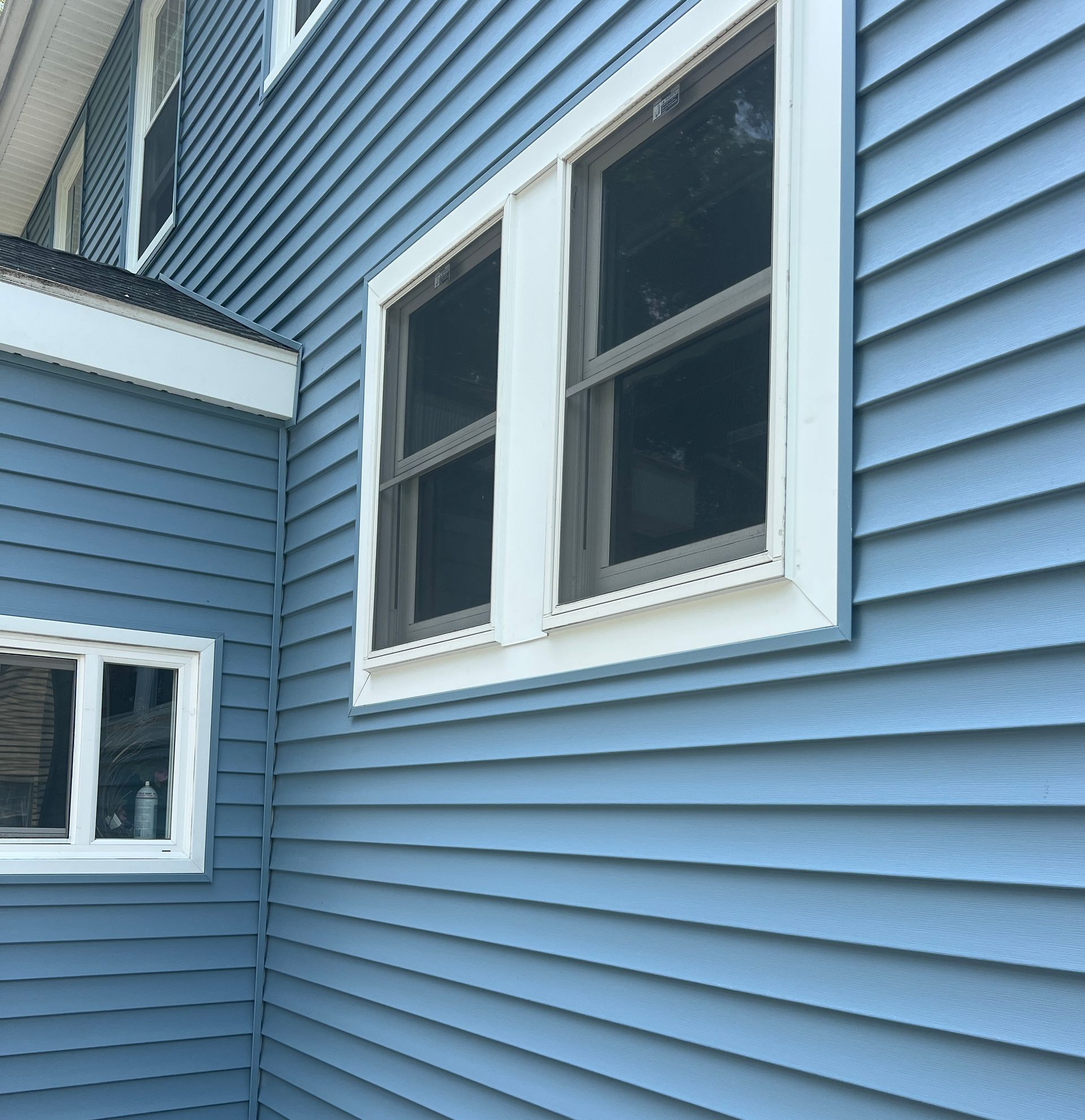 Blue siding with white trim and windows on a house.