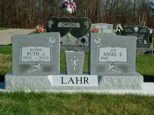 A couple of graves in a cemetery with the name lahr on the top