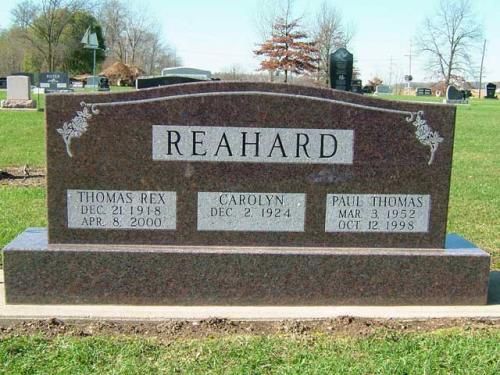 A gravestone for thomas rex , carolyn , and paul thomas in a cemetery.