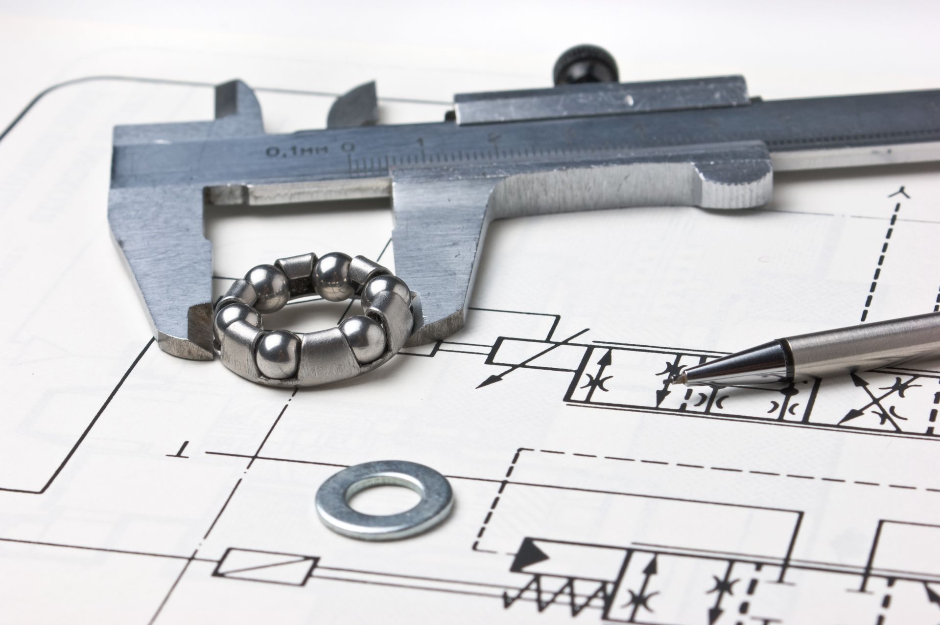 Calipers Measuring A Ball Bearing On Top Of An Engineering Blueprint — GS Design & Drafting In Rous, NSW