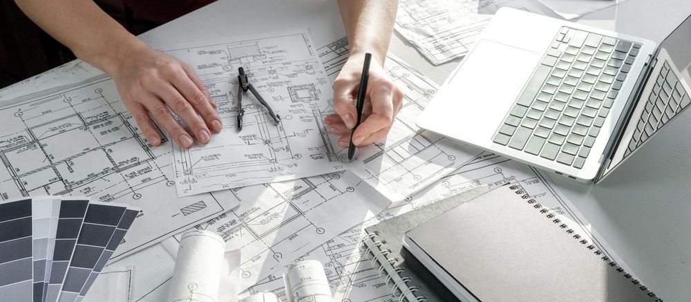Hands Working On Architectural Blueprints With A Laptop — GS Design & Drafting In Byron Bay, NSW