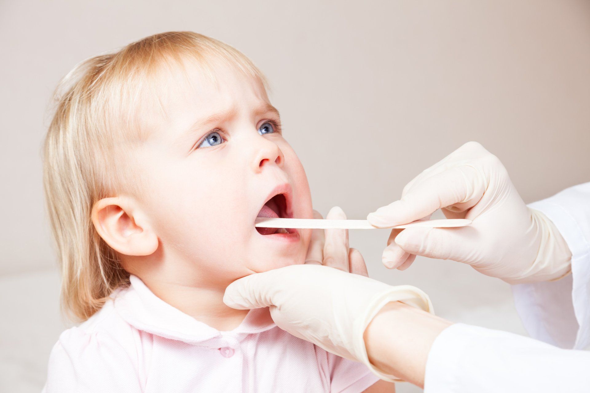 doctor looking in toddler's mouth