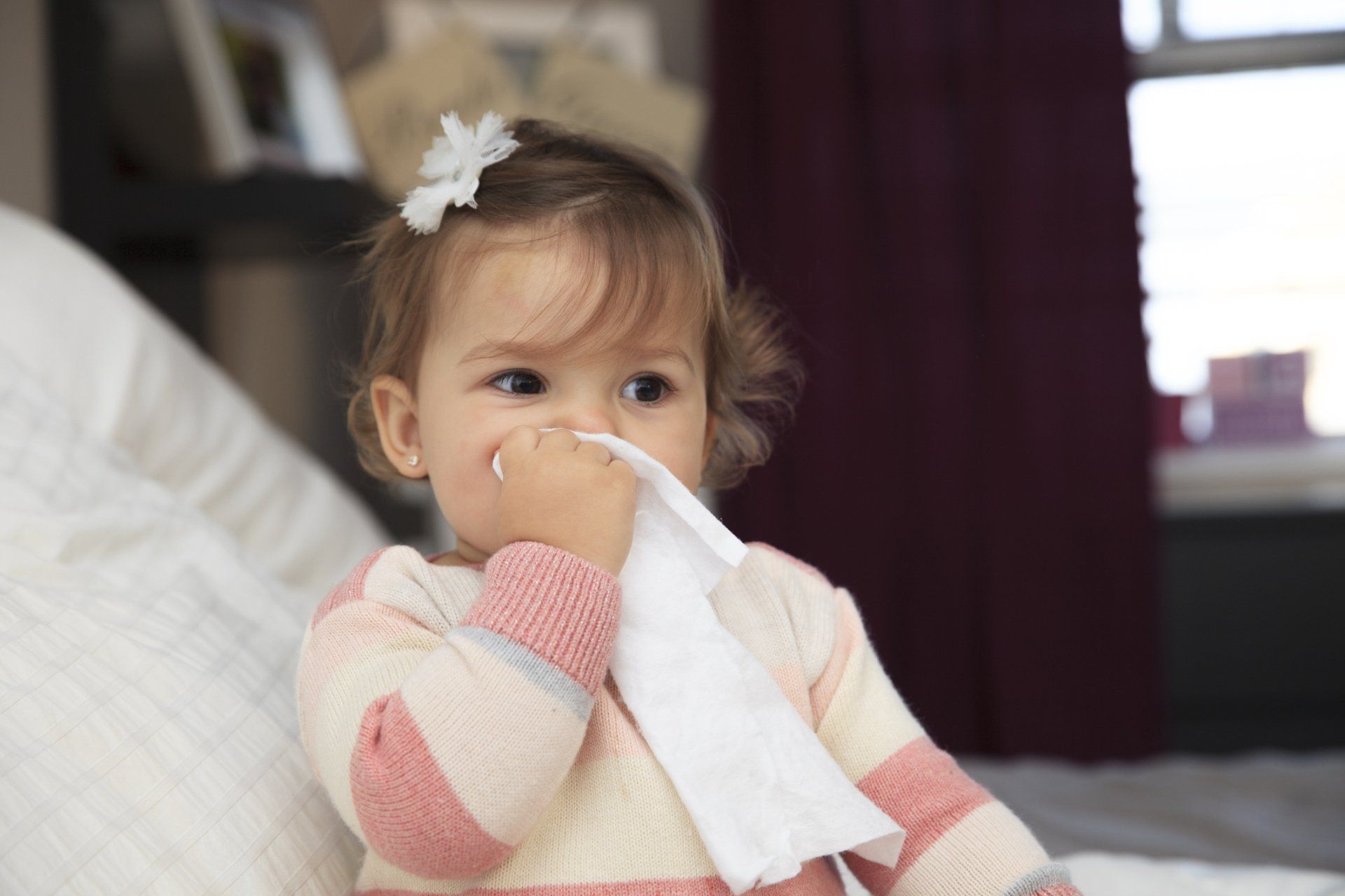 toddler girl blowing nose
