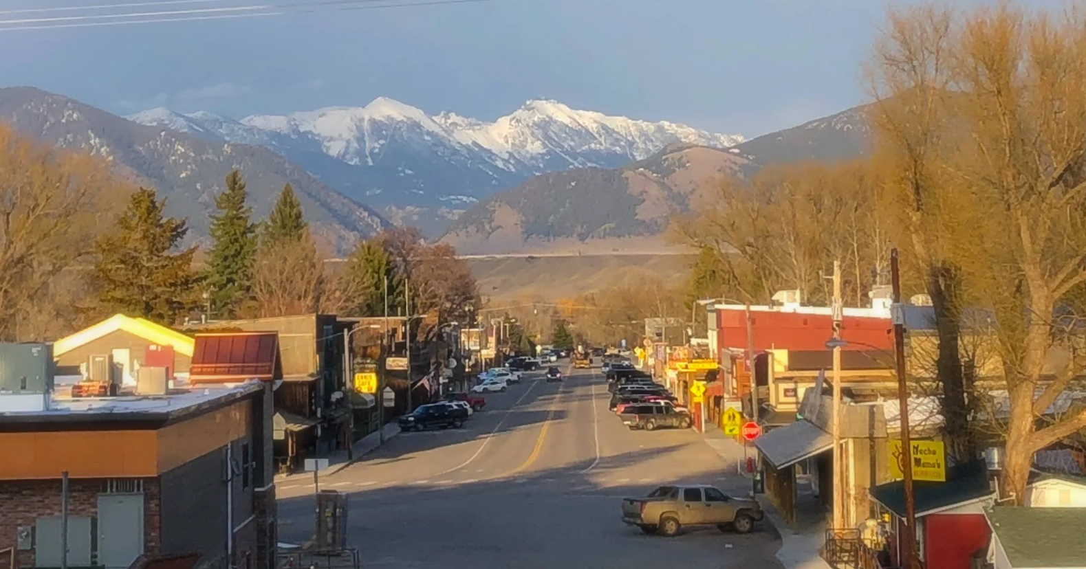 A street in a small town with mountains in the background.